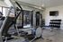Modern apartment gym featuring state-of-the-art exercise equipment, including treadmill, elliptical, and free weights for an optimal fitness experience.