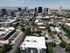 Vibrant cityscape view showcasing a mix of modern skyscrapers and charming residential areas against a backdrop of majestic mountains.