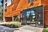 Contemporary apartment facade with sleek black and warm wood paneling at Salt Flats Living, featuring large glass doors and lush landscaping.
