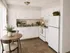 Bright and cozy kitchen featuring white cabinets, modern appliances, and a charming dining nook with natural light.
