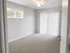 Bright and airy bedroom with plush carpeting, large window, and sliding glass door leading to a private outdoor space.