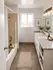 Elegant bathroom with dual sinks, modern lighting, and a cozy bathtub, enhanced by decorative plant accents and a soothing ambiance.