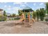 Inviting playground nestled in a lush community setting with mountain views in the background.