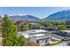 Gorgeous apartment complex with classic architecture, surrounded by lush greenery and stunning snow-capped mountain views.