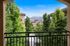 Stunning balcony view of lush greenery and snow-capped mountains, framed by elegant architecture.