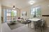 Elegant modern living room with large windows, stylish furniture, and a chic dining area creating a bright and welcoming atmosphere.