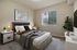 Modern bedroom with a cozy upholstered bed, large window, stylish bedside lamps, and elegant decor, creating a warm and inviting atmosphere.