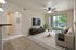 Modern living room with a sleek entertainment area, plush seating, and a large window offering a scenic view, creating a bright and inviting space.