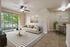 Bright and welcoming living area with modern furniture, stylish decor, and large windows offering lush green views.
