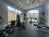 Bright and modern fitness center with state-of-the-art gym equipment, large windows, and a pool view.
