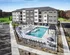 Luxurious apartment complex with a modern facade and inviting outdoor pool area, perfect for relaxation and enjoyment.