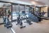 Modern fitness center with state-of-the-art exercise equipment and large windows offering a view of the pool area.