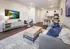 Modern open-concept living room with stylish furnishings, cozy seating, and a sleek kitchen island.