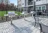 Chic outdoor patio with modern stainless steel grills, perfect for entertaining, set in an elegant apartment complex with lush green lawn.