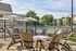 Inviting outdoor space featuring stylish Adirondack chairs around a fire pit, with a shimmering pool and sun umbrellas providing a relaxing retreat.