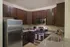 Modern kitchen with sleek stainless steel appliances, dark wood cabinetry, and elegant granite countertops.