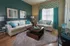 Elegant living room with chic teal accents, plush white sofas, and modern decor creating a cozy ambiance.
