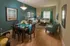 Elegant living and dining area with modern decor, featuring plush sofas, stylish dining set, and vibrant teal accents.