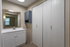 Bright bathroom with modern vanity sink, large mirror, and ample storage space.