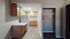 Charming kitchen space with wooden cabinetry, modern appliances, and elegant flooring in a cozy apartment setting.