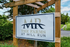 Inviting entrance sign for The Farms at Mill Run, nestled in lush greenery and welcoming future residents.