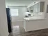 Modern kitchen with sleek black appliances, white countertops, and elegant cabinetry under soft recessed lighting.