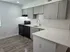 Modern kitchen with sleek gray cabinets, stylish black appliances, and a bright, spacious countertop perfect for entertaining.