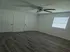 Bright bedroom with stylish wood flooring, dual closets, and modern ceiling fan, perfect for a cozy living space.