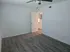 Bright and spacious bedroom with modern wood flooring and ceiling fan, offering a serene and inviting atmosphere.
