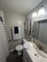 Bright and modern bathroom featuring sleek fixtures, elegant artwork, and inviting neutral tones.