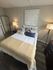 Cozy bedroom with elegant decor, featuring a plush bed, stylish floor lamp, and inspiring wall art reading 'Dream Big'.