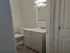 Compact and modern bathroom with sleek vanity, pristine sink, and elegant lighting.