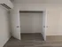 Elegant closet space with sleek white double doors and modern hardwood flooring, complemented by efficient air conditioning for a comfortable living experience.