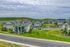 Charming apartment community set against lush green hills, featuring well-maintained buildings with balconies and spacious parking, ideal for serene living.