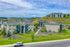Charming hillside apartment complex with lush green surroundings and modern architecture, offering serene living with stunning landscapes.