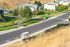 Charming suburban neighborhood view featuring modern apartment buildings, lush green lawns, and convenient bus stops along a quiet street.