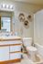 Contemporary bathroom with chic hexagonal wall shelves, pristine white fixtures, and a stylish vanity mirror highlighting a fresh, vibrant look.