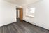 Bright and airy bedroom with modern wood flooring and large window offering natural light.