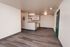 Open-concept apartment with modern kitchen and elegant hardwood floors, offering a spacious and inviting living area.