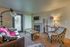 Inviting living room featuring a cozy fireplace, stylish seating, and a contemporary design with natural lighting.