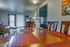 Charming living and dining area with elegant wooden furnishings, vibrant decor accents, and modern lighting, offering a welcoming and stylish atmosphere.