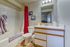 Inviting bathroom with modern fixtures, featuring a sleek vanity, classic shower-tub combo, and vibrant red shower curtain accented by cozy towels.