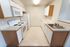 Contemporary kitchen with sleek white cabinetry, modern appliances, and abundant countertop space for culinary creativity.