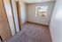 Cozy sunlit bedroom with plush carpeting, wooden closet doors, and a scenic window view for natural light and warmth.