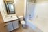 Bright and modern bathroom featuring a sleek vanity, toilet, and spacious bathtub with shower.