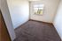 Bright and cozy bedroom with plush carpeting, natural light pouring in from a large window, and scenic views outside.