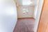 Bright and inviting bedroom with plush carpet and a large window offering scenic views, perfect for relaxation.