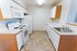 Modern kitchen with sleek white cabinets, spacious countertops, and fully equipped appliances.