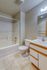 Bright and modern bathroom featuring a sleek bathtub, elegant vanity, and soft-toned tiles for a relaxing ambiance.