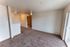 Bright and airy living space with plush carpet flooring, neutral walls, and modern lighting, perfect for relaxation or entertaining.